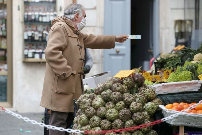 Một người đàn ông đang mua hàng tại chợ ở Rome (Italy).