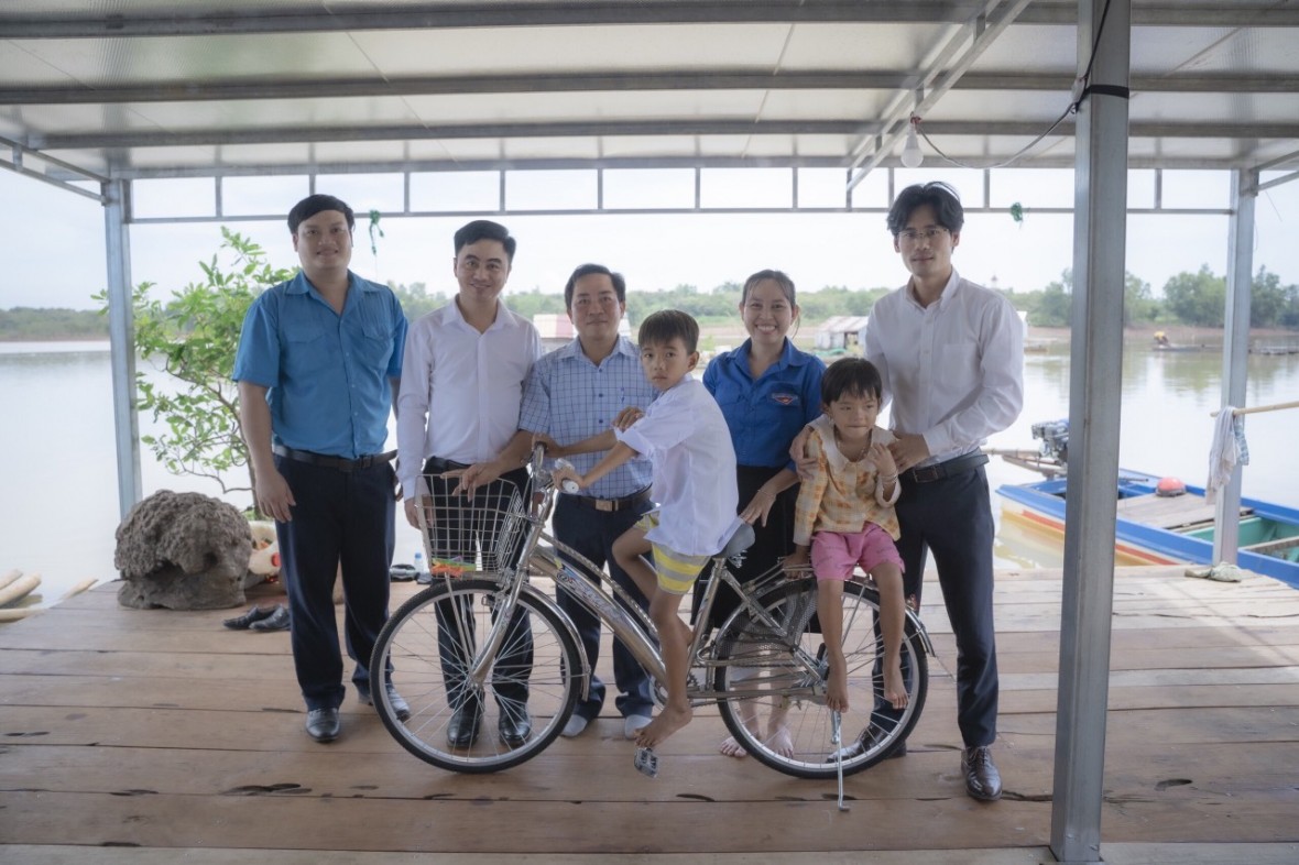 Ông Đào Văn Huy, Trưởng VP Đại diện phía Nam Tạp chí Nhà Đầu tư (bìa phải) cùng Giám đốc TT XTĐT,TM&DL tỉnh Trần Quốc Duy (thứ 2, trái sang) thăm, trao xe đạp cho em Trần Văn Chủ (trường TH Phước Minh) - con em Việt kiều Campuchia.